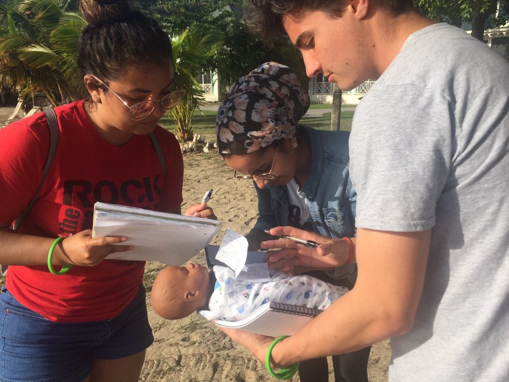 Students on beach with fake baby