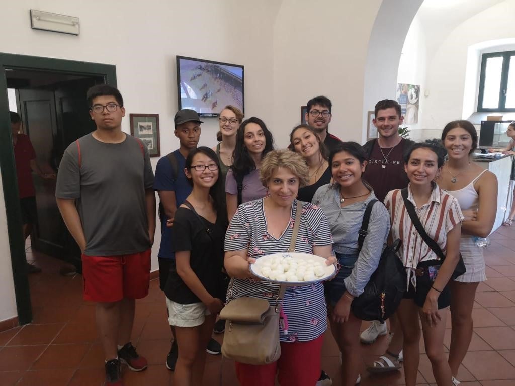 UIC students on the Italian Language and Culture in Salerno program with faculty member Maria Iusco. Maria is holding a plate of Italian food.