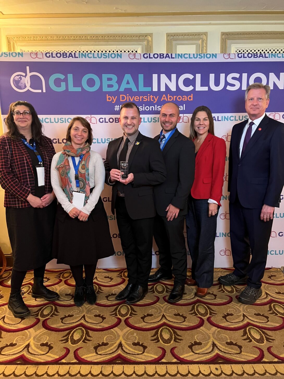 Staff members of the Study Abroad Office pose with the EDIIE award at the 2023 Diversity Abroad Global Inclusion Conference.
